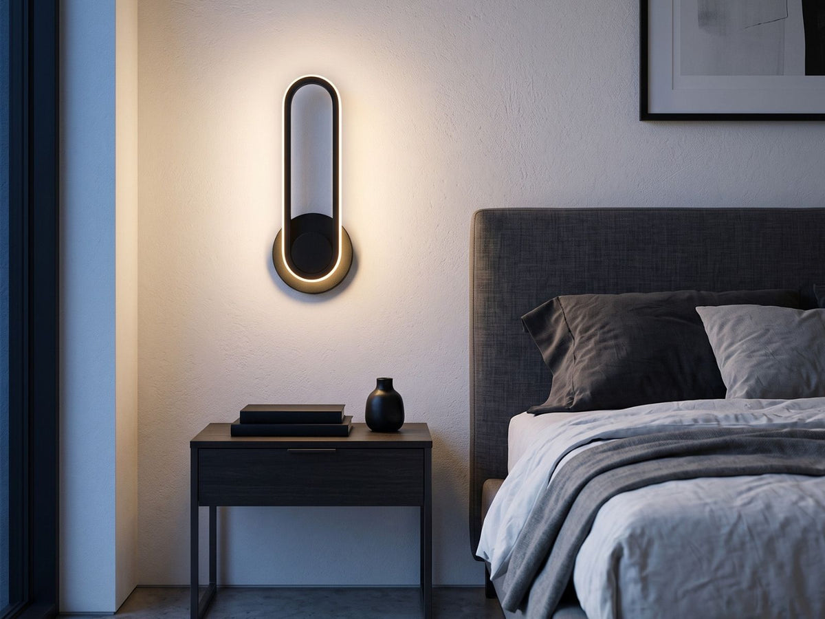 Black oval ring wall sconce mounted beside bed in modern bedroom