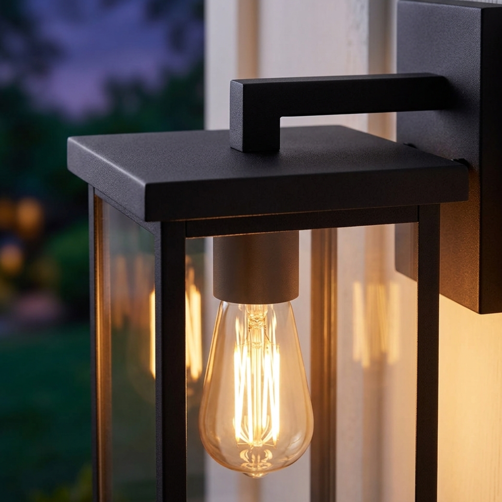 Pair of black outdoor wall lanterns with clear glass beside a front door