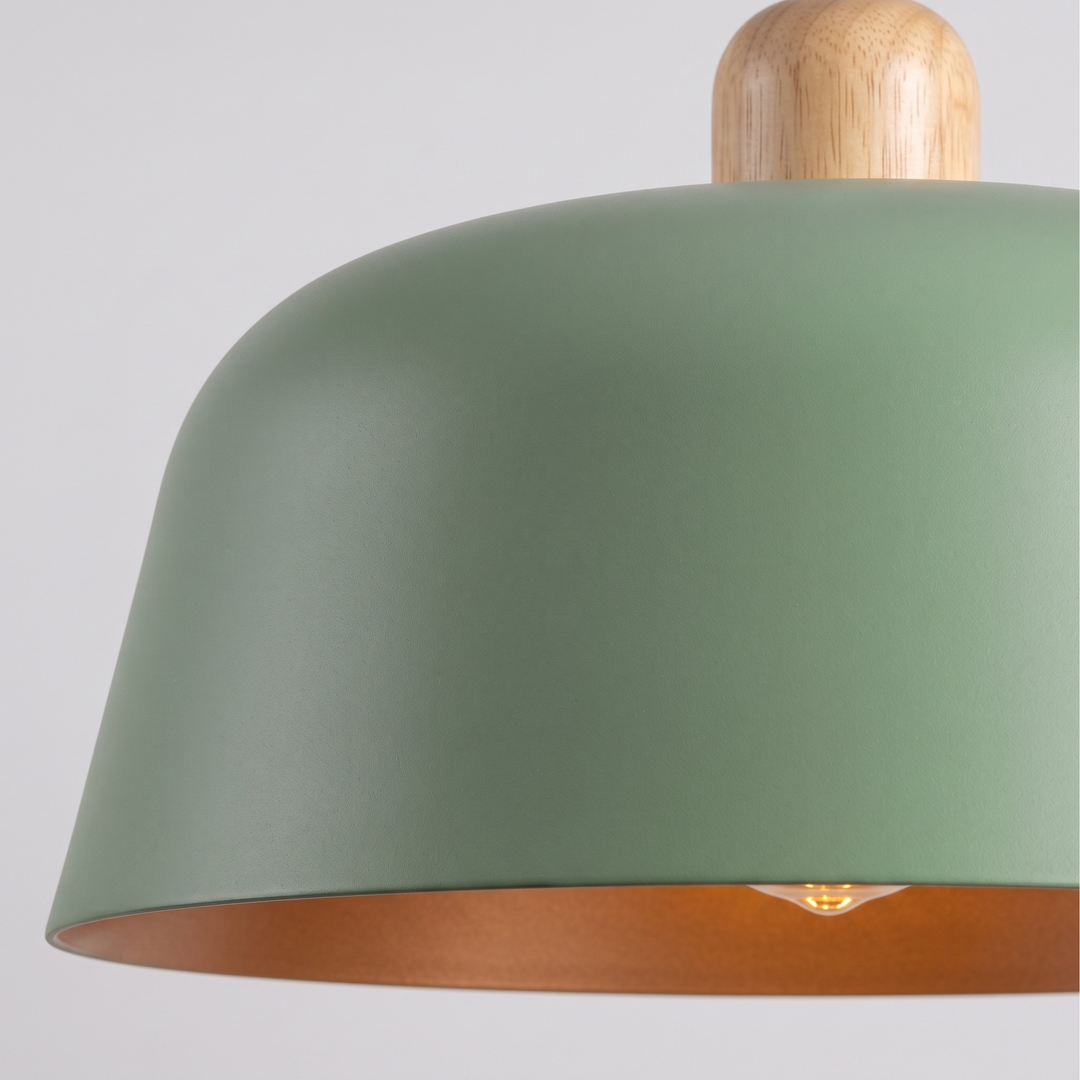 Close-up of matte sage green dome shade with natural wood top piece