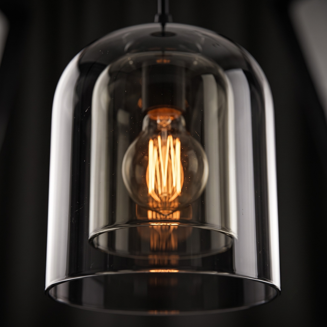 Smoked glass pendant light hanging above wooden nightstand in modern bedroom