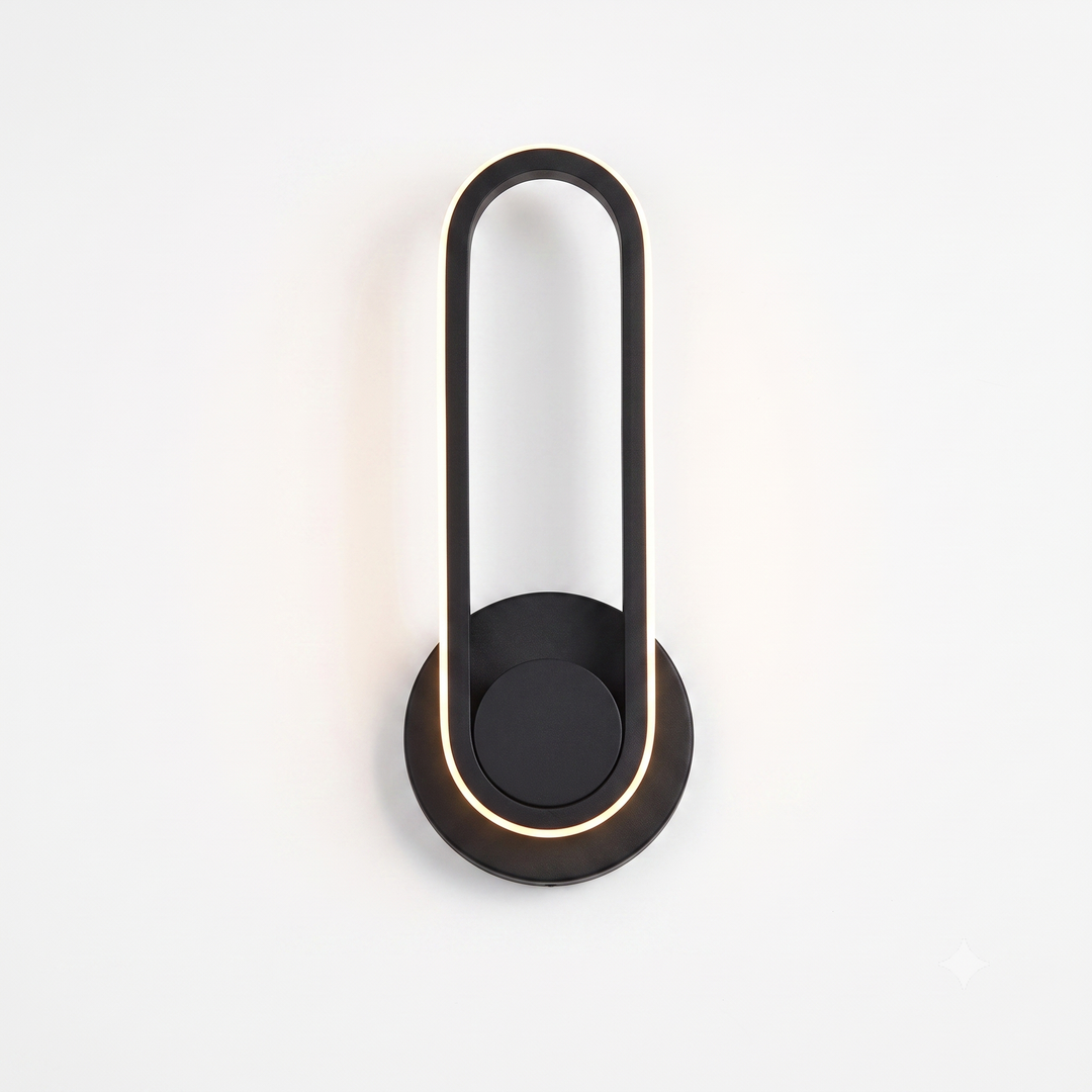 Black oval LED wall sconce with warm white glow on white background